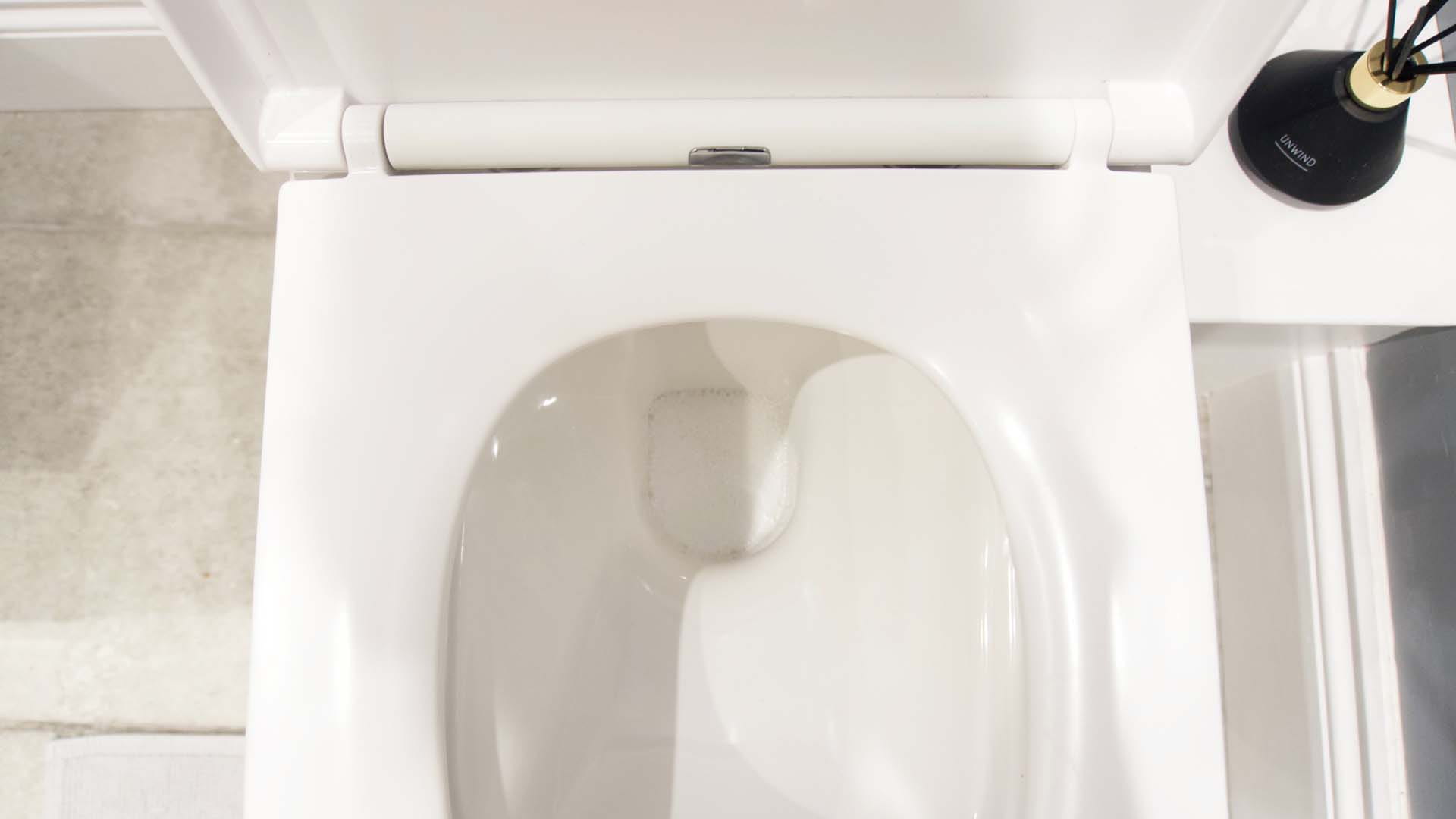 A toilet with a fizzing homemade toilet bomb in the bowl
