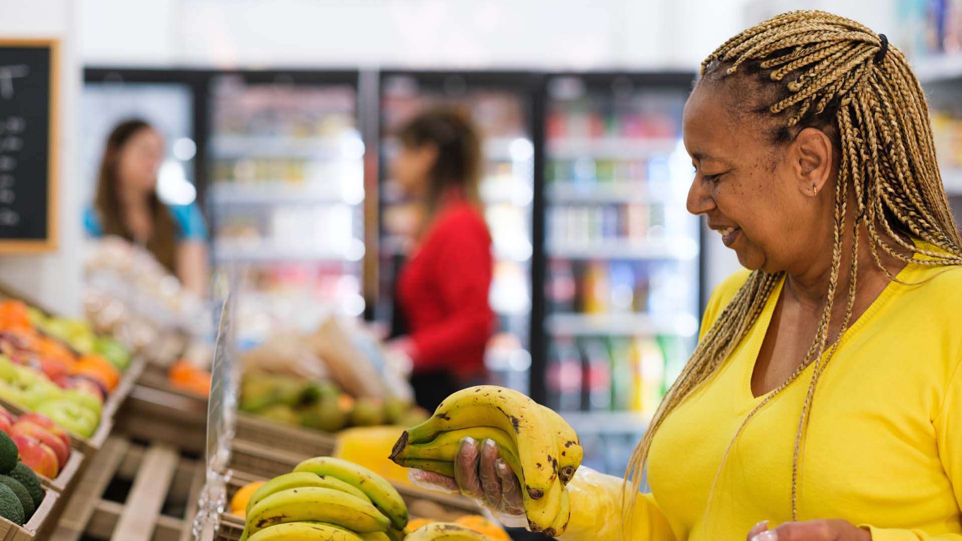 A woman choosing bananas in a supermarket