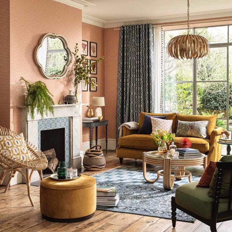 A boho-styled front room with peach walls and a large window