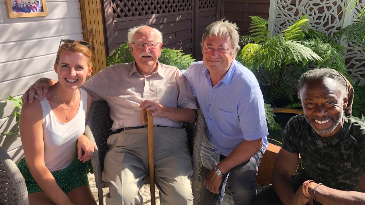 Katie Rushworth, Grandfather and friends pose in a sunny back garden