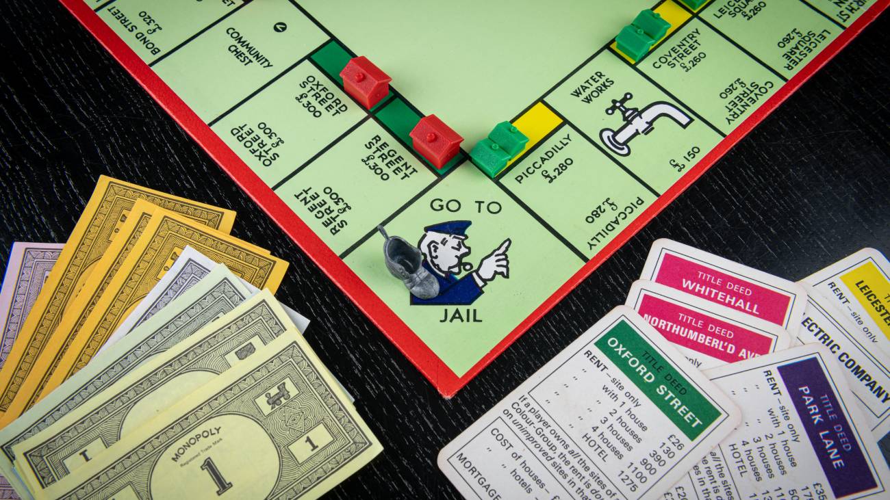 A board game of Monopoly, with cash at the board game and monopoly cards