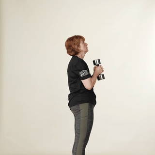 Woman holding weight behind head and lifting it up and down