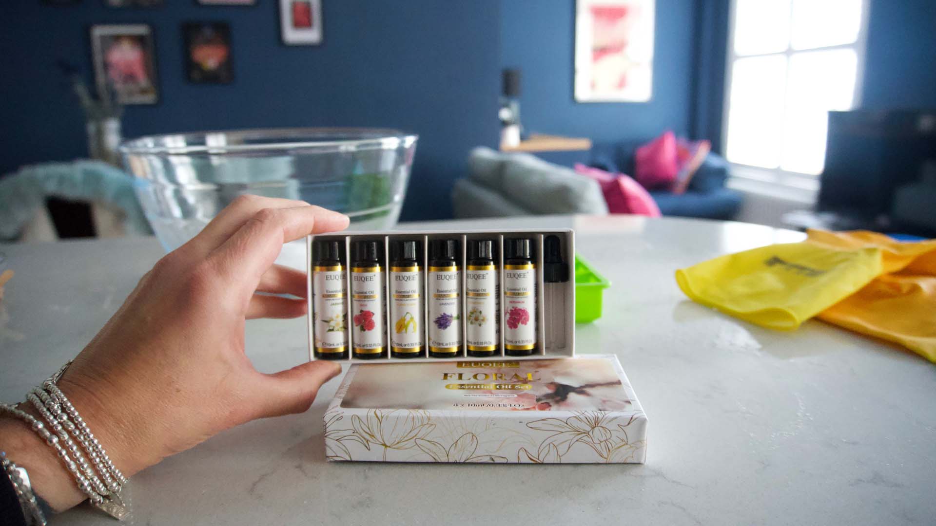 A hand holding a box of essential oils vials