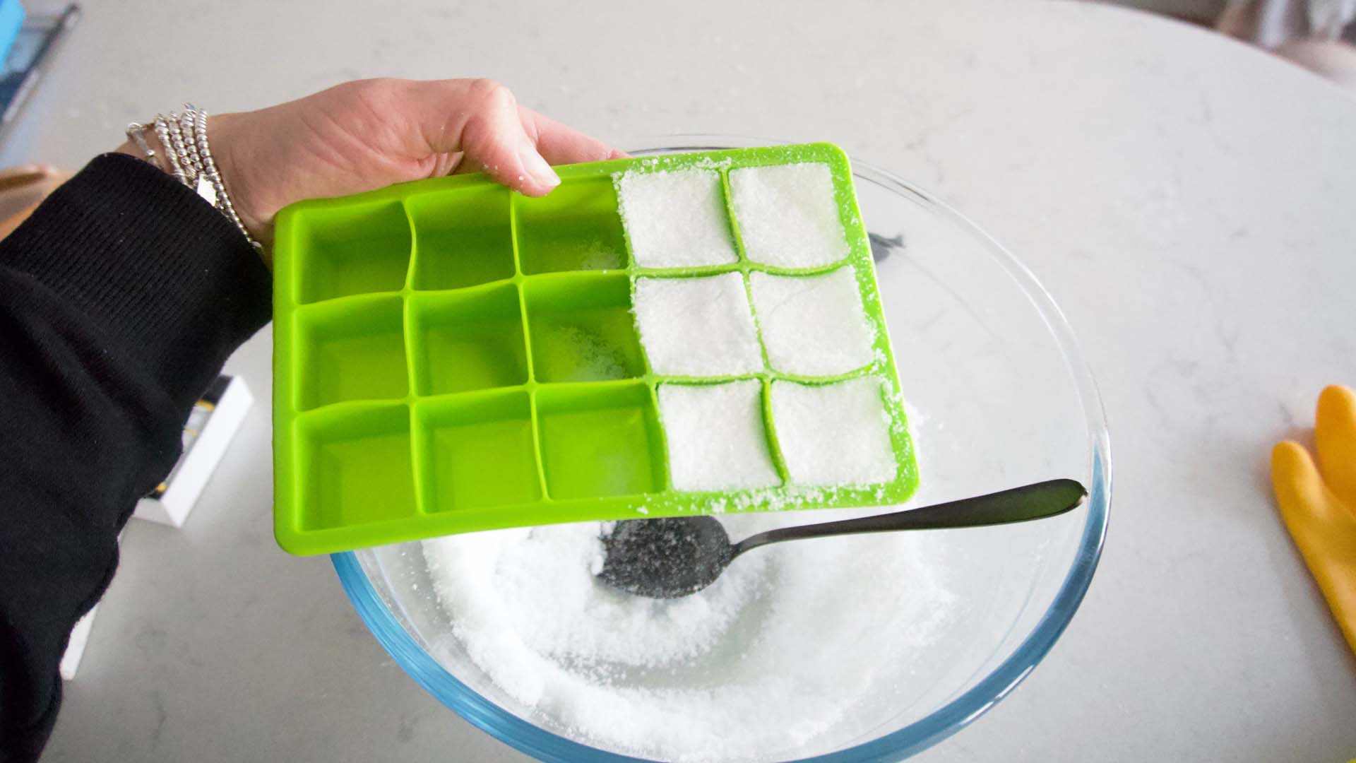 Filling the ice cube tray with the toilet bomb mixture