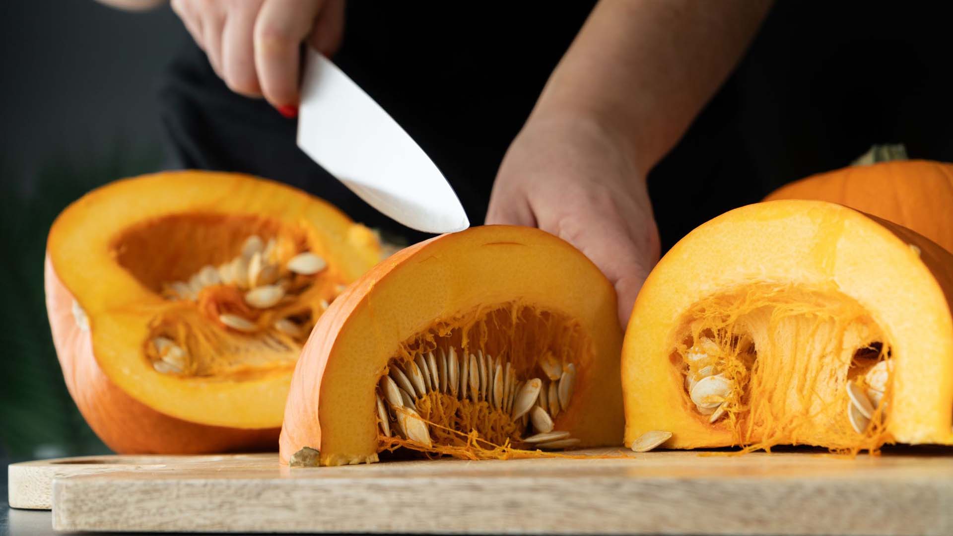 Woman cutting pumpkin into quarters
