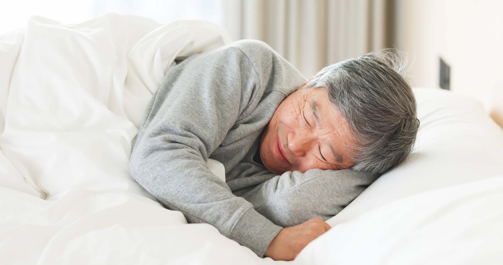 Man asleep on his side in bed