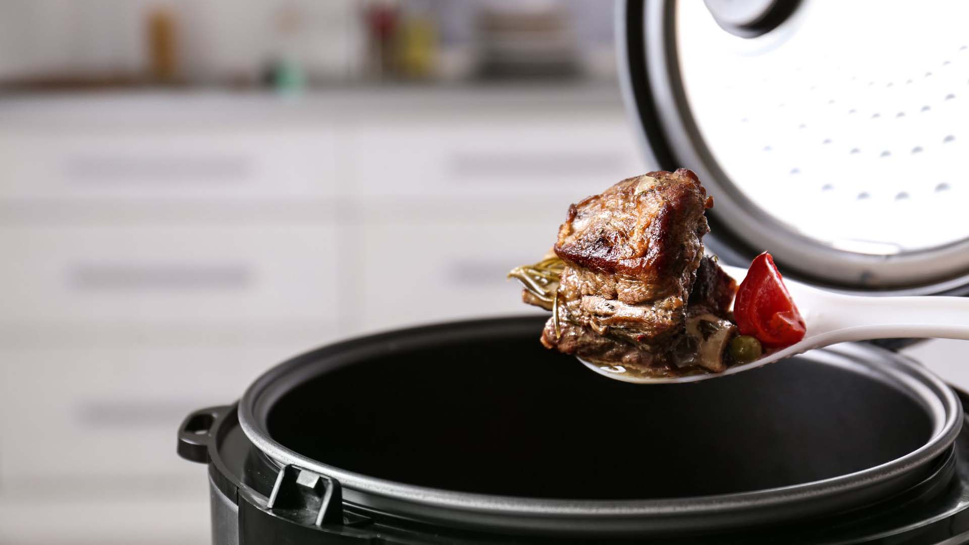 A spoonful of meat coming out of  slow cooker