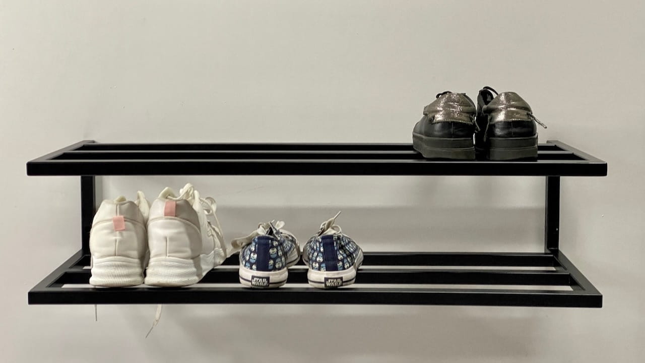 Black metal shoe rack on wall