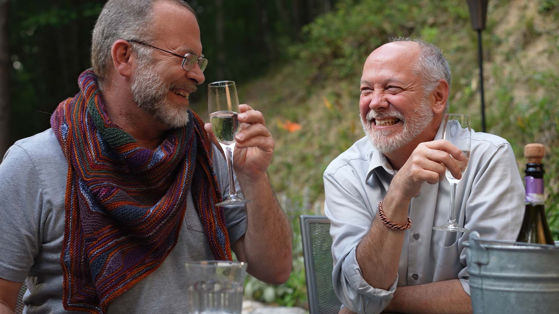Two older men enjoy a glass of wine together