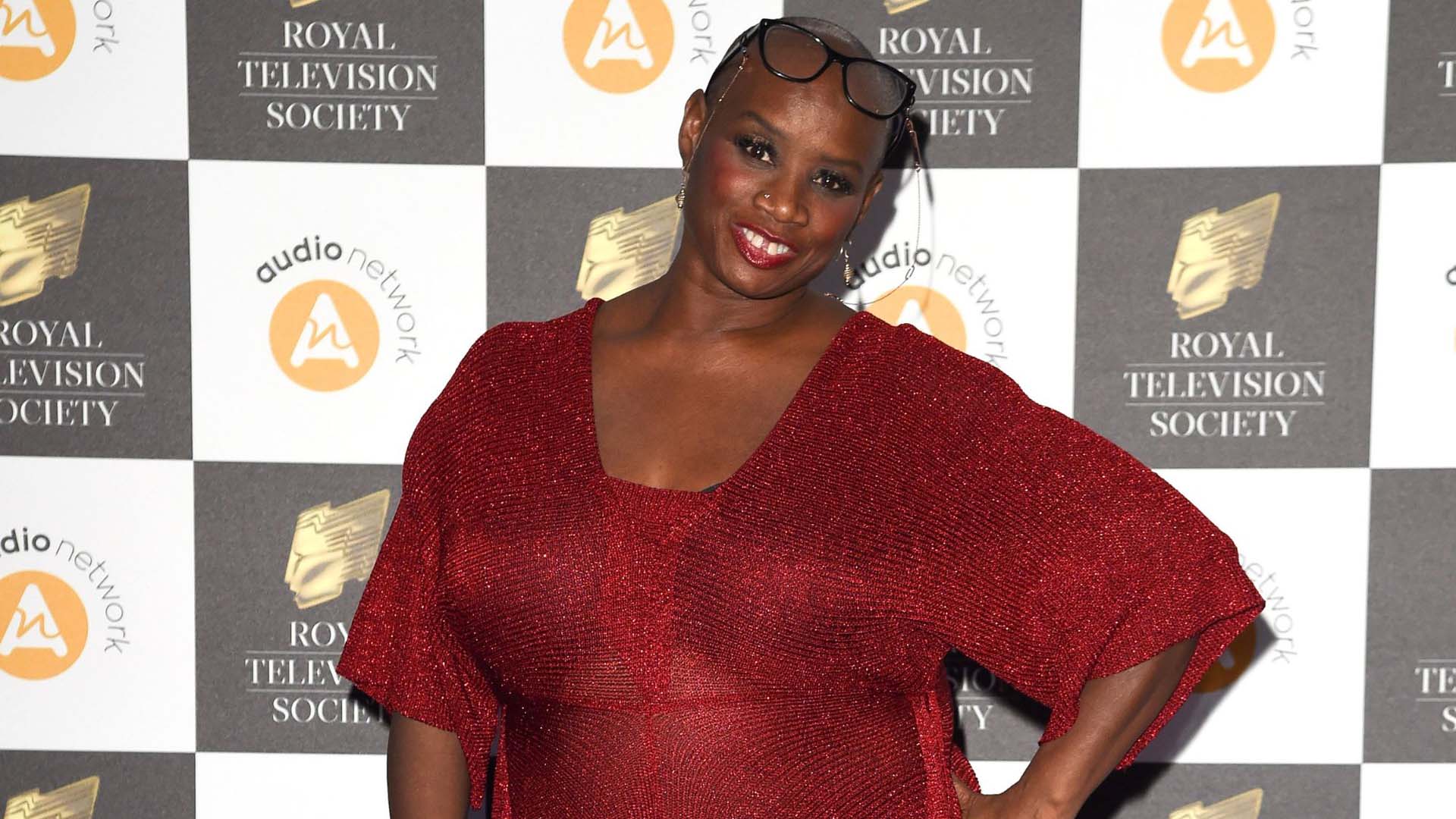 Headshot of Andi Oliver on the red carpet in a red dress
