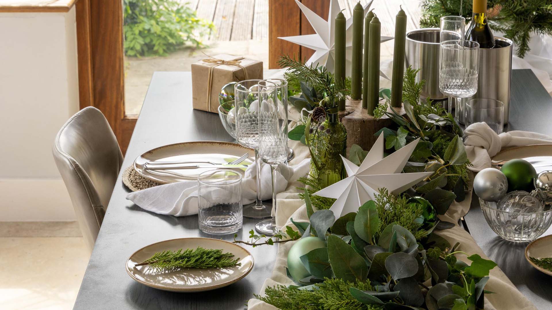 A festive table setting decorated with green foliage