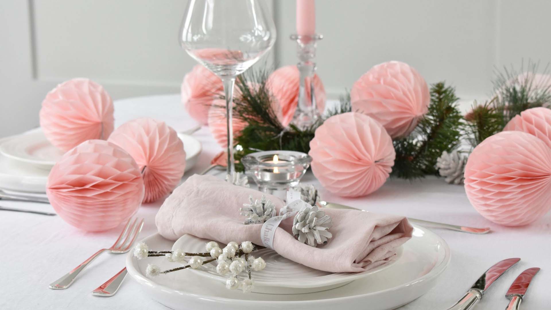 Pale pink paper baubles decorate a festive table