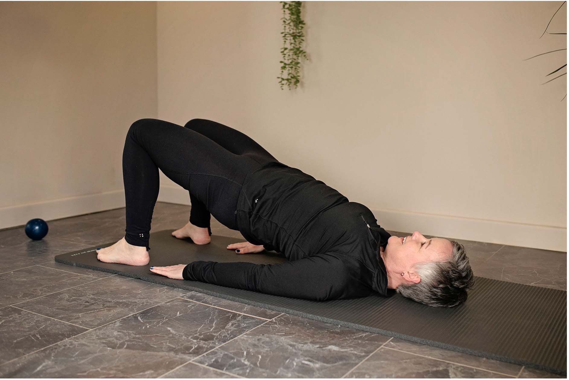 Demonstrating Pilates bridge position