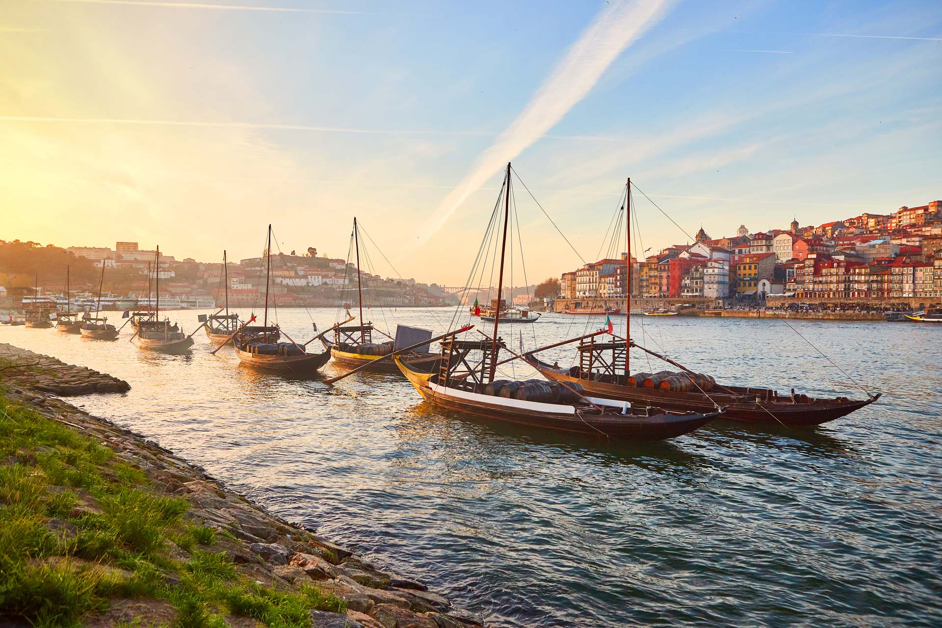 A view of the river with the city of Porto in the background and old fashioned sailboats in the foreground
