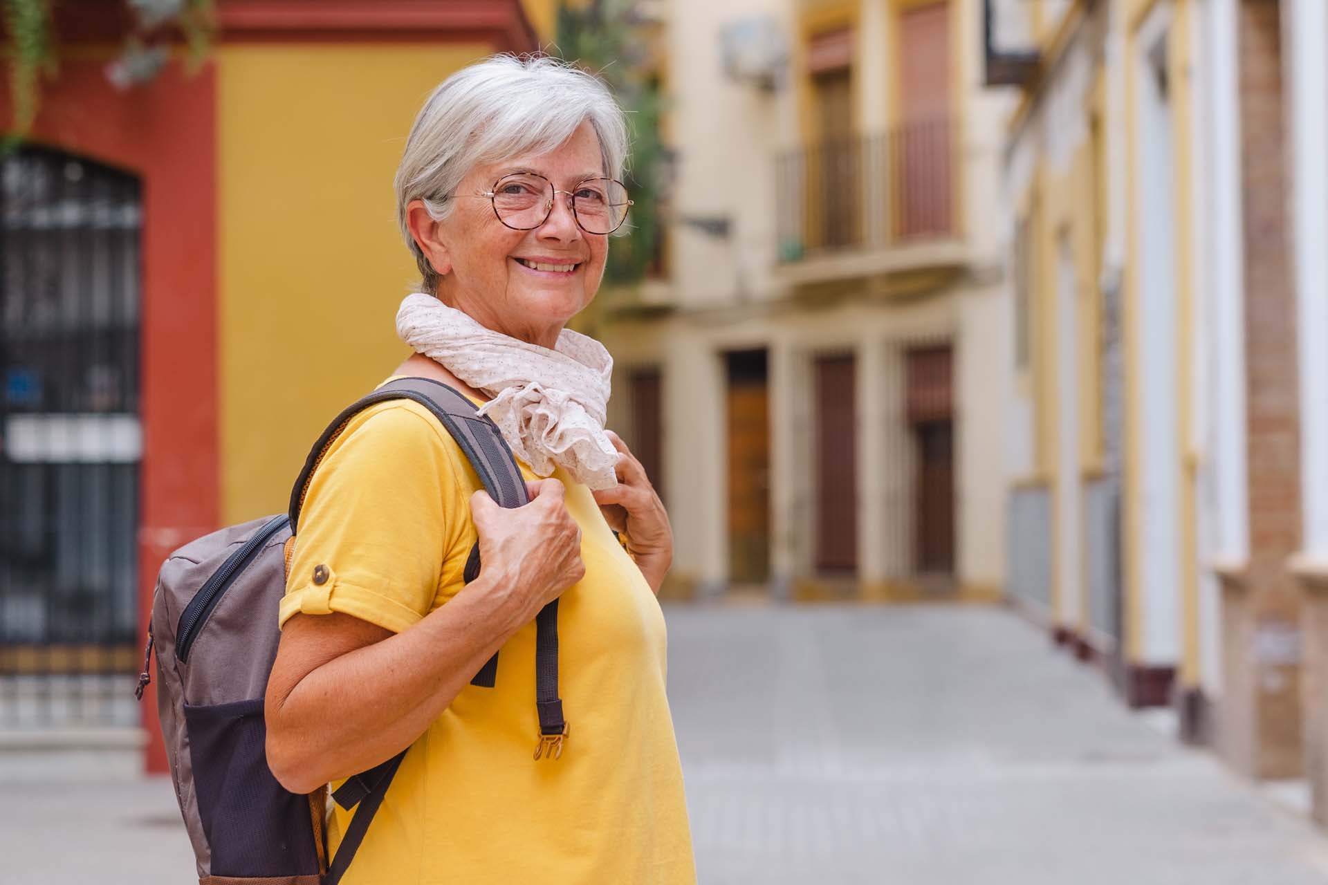An older traveller smiles at the camera during her holiday