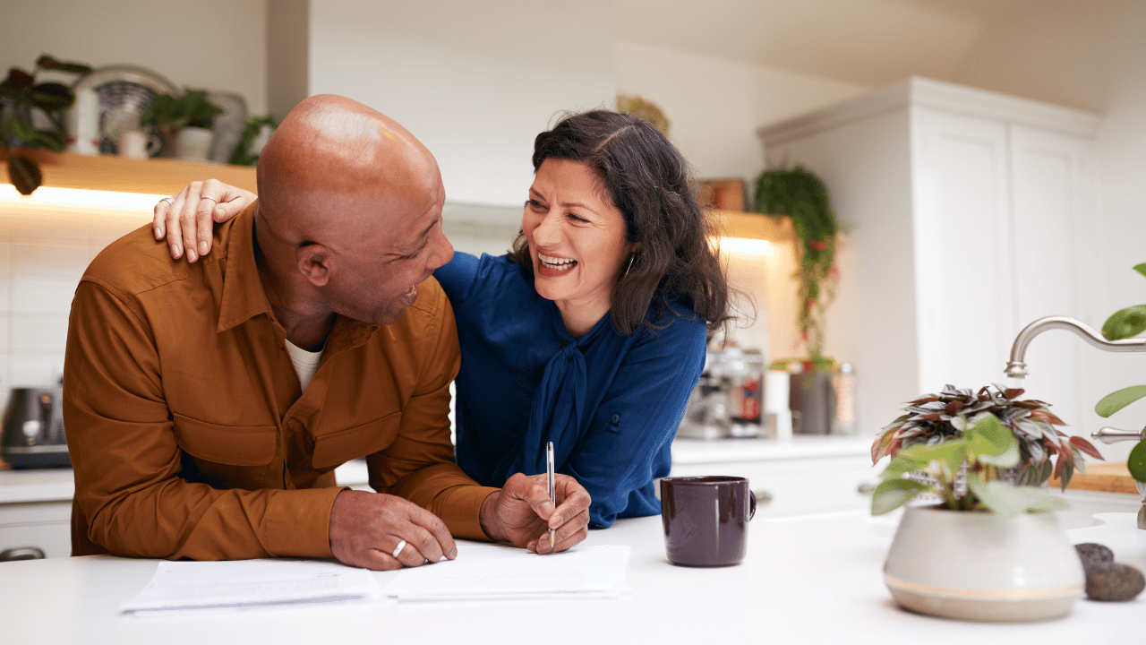 Couple signing a document in kitchen