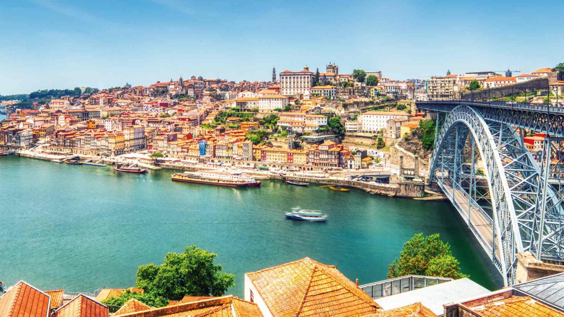 Panoramic view of Porto, Portugal with the Douro River, historic buildings, and the Dom Luís I Bridge.