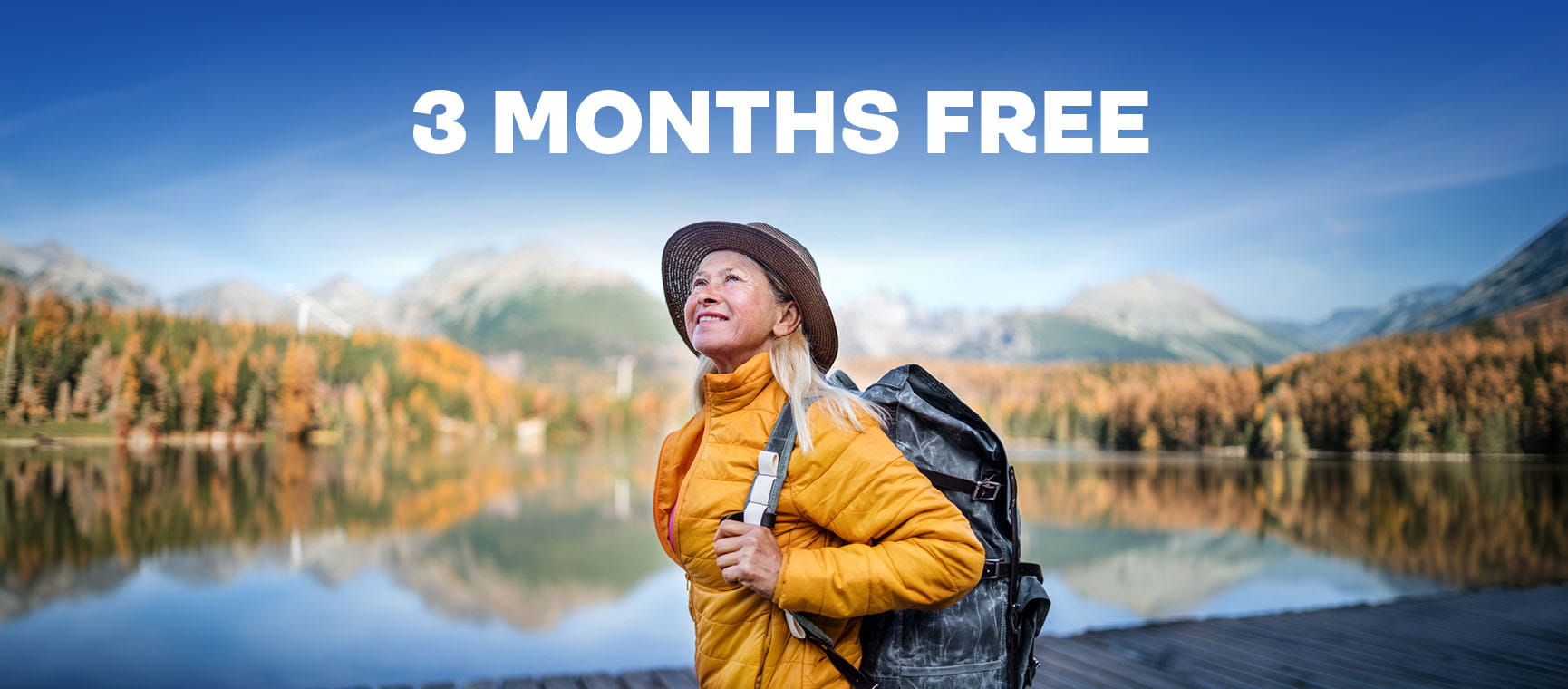 Promotional banner reading “3 MONTHS FREE” above a person with a backpack standing by a mountain lake.