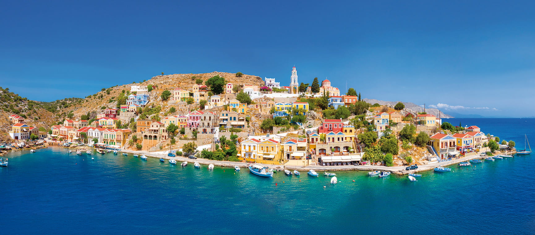 Coastal town with colourful buildings along clear blue sea