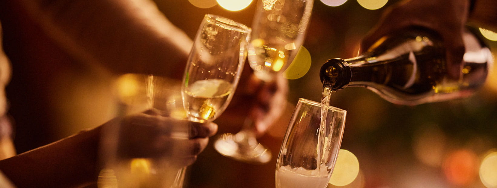 Close-up of champagne being poured into glasses during a celebration.