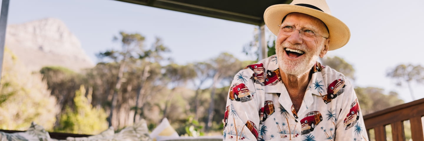 Happy elderly man laughing cheerfully while relaxing on a couch at a luxury spa resort