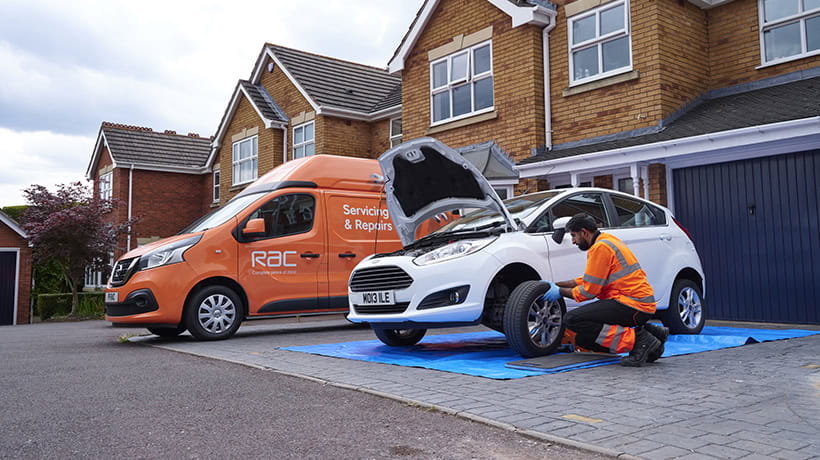 An RAC Mobile Mechanic fixing a vehicle on the driveway of their house.