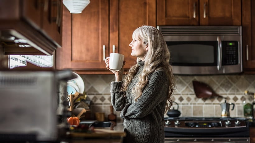 Portrait of a mature woman having coffee in kitchen