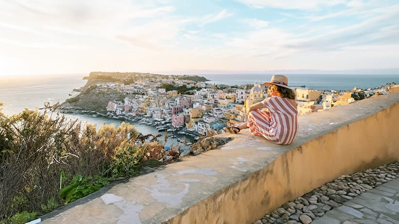 A holidaymaker watching the sunset over a beautiful Greek seaside town