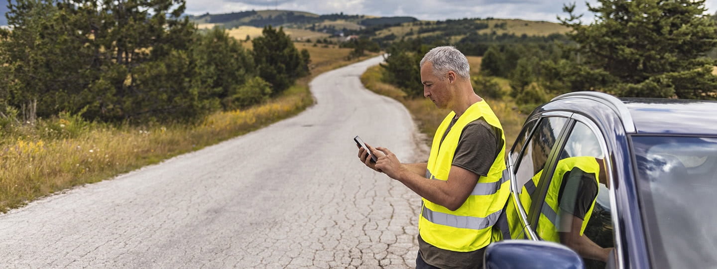 Frustrated mature man calling roadside assistance after breaking down.