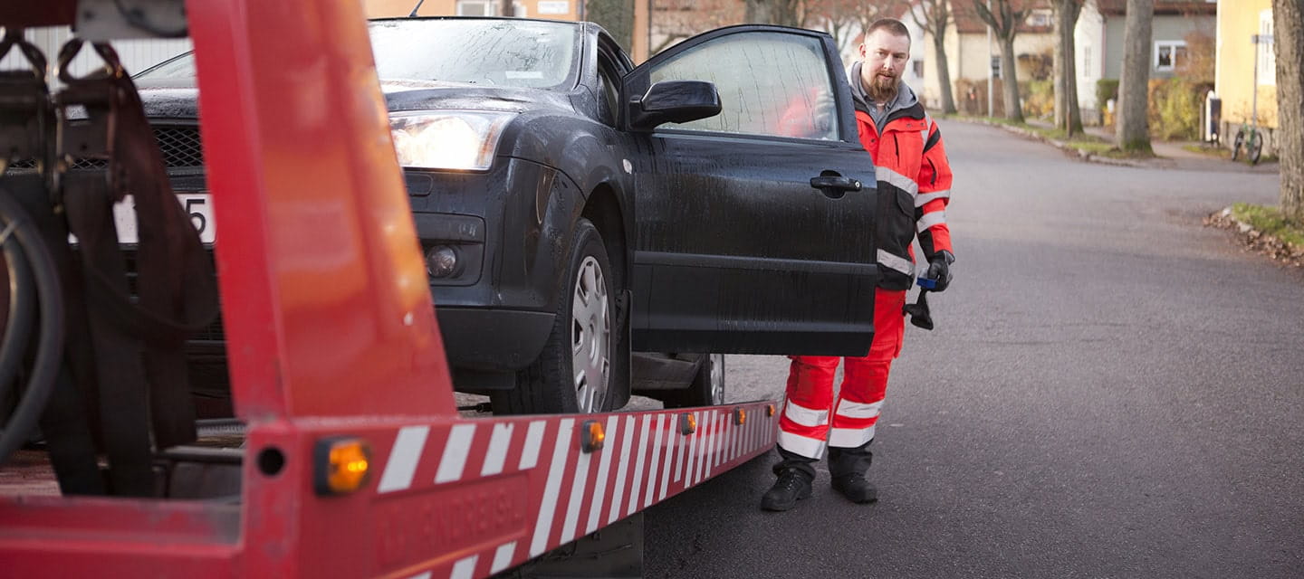 A man preparing a car to get towed