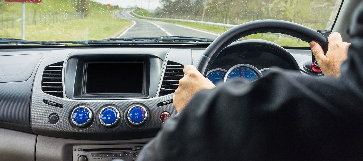 View from a car's interior as a man drives on a rural road in Perthshire, Scotland