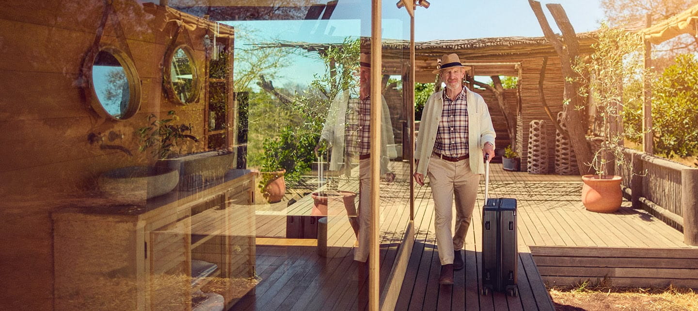 A mature man walks confidently toward a hotel room at a Safari resort in South Africa.