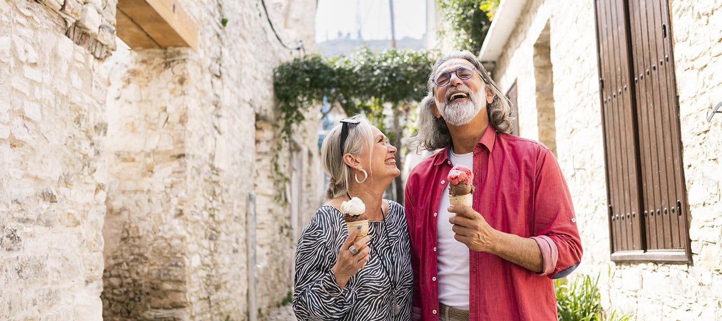Mature tourists enjoying local ice cream while walking through an old town in Cyprus