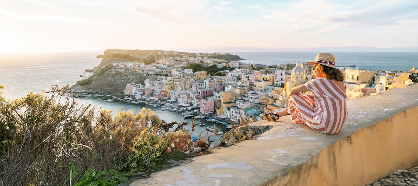 A holidaymaker watching the sunset over a beautiful Greek seaside town