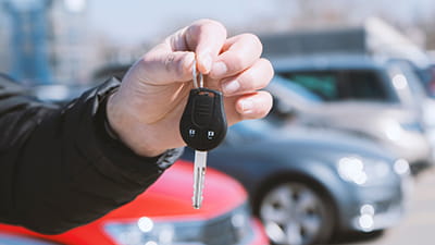 A hand holding a single car key