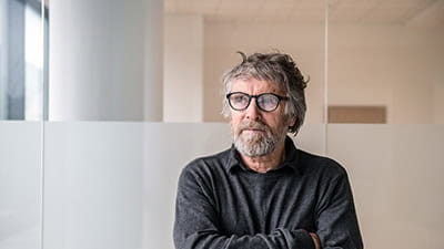 Senior man sat alone wearing glasses.