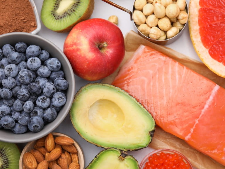 Different healthy foods on white table, flat lay | Getty/Liudmila Chernetska
