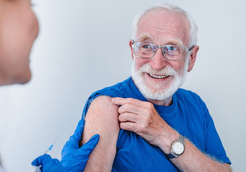 An older man about to receive a vaccination injection