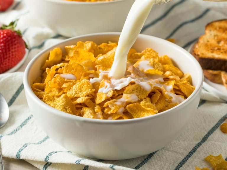 Milk being poured into a bowl of cornflakes