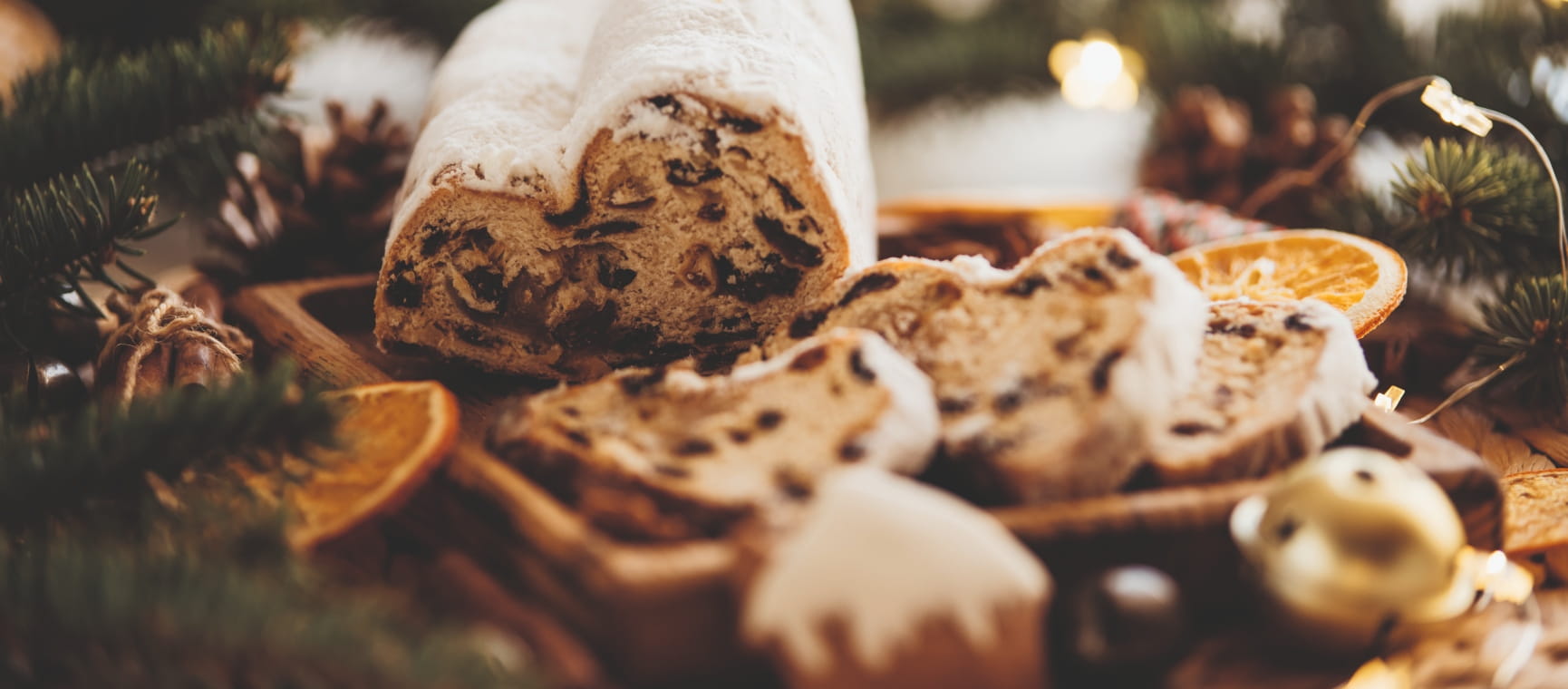 A traditional marzipan stollen cake with slices of cake served on a wooden tray