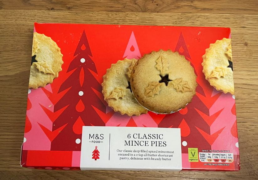 A box of marks and spencer mince pies on a wooden table top