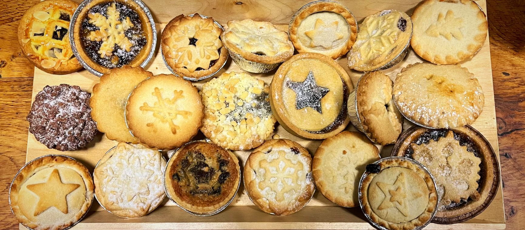 A rectangular plate full of different types of mince pies