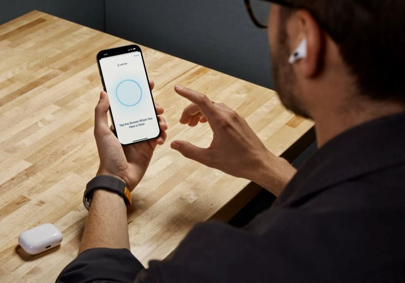 man managing his Apple earphones from his phone
