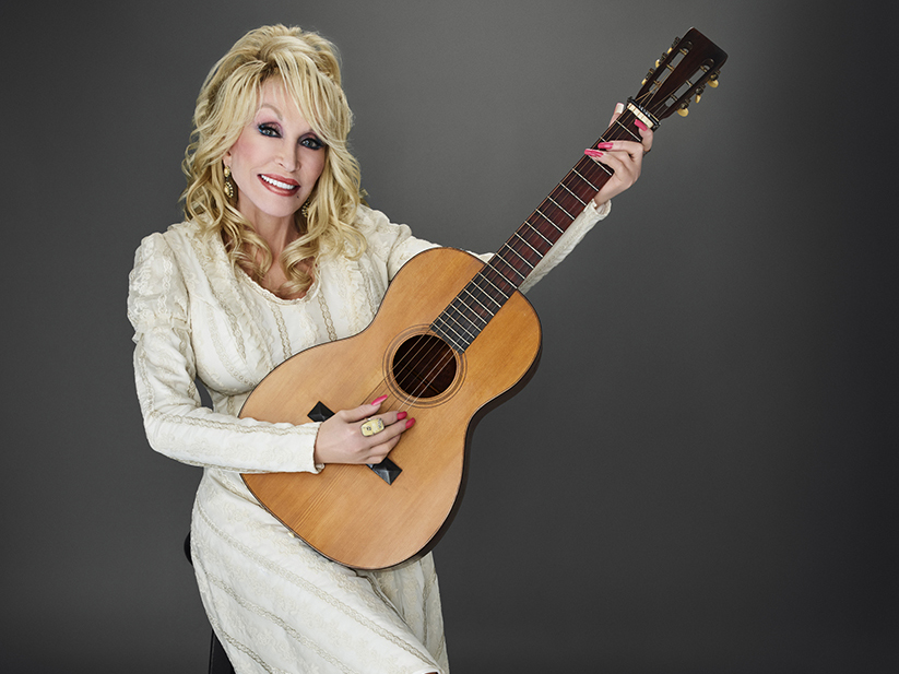 Dolly Parton playing her guitar