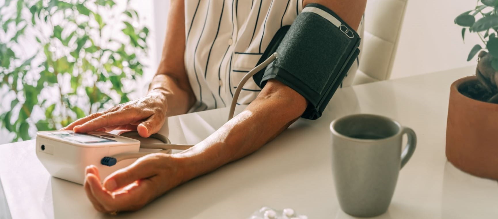 Woman's arm with the blood pressure monitor