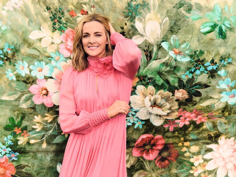 Gabby Logan in a pink dress smiling at the camera | Elisabeth Hoff