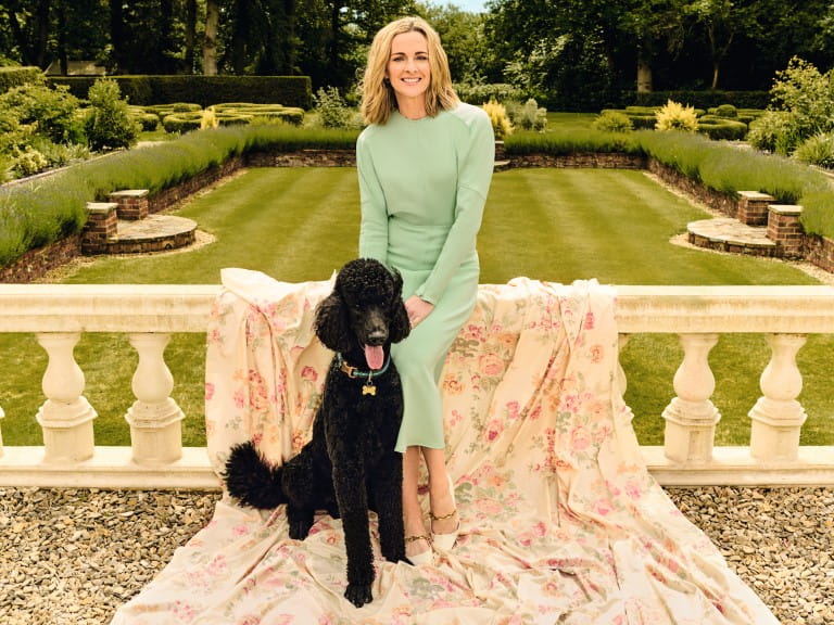 Gabby Logan poses against a beautiful garden with her black poodle | Elisabeth Hoff