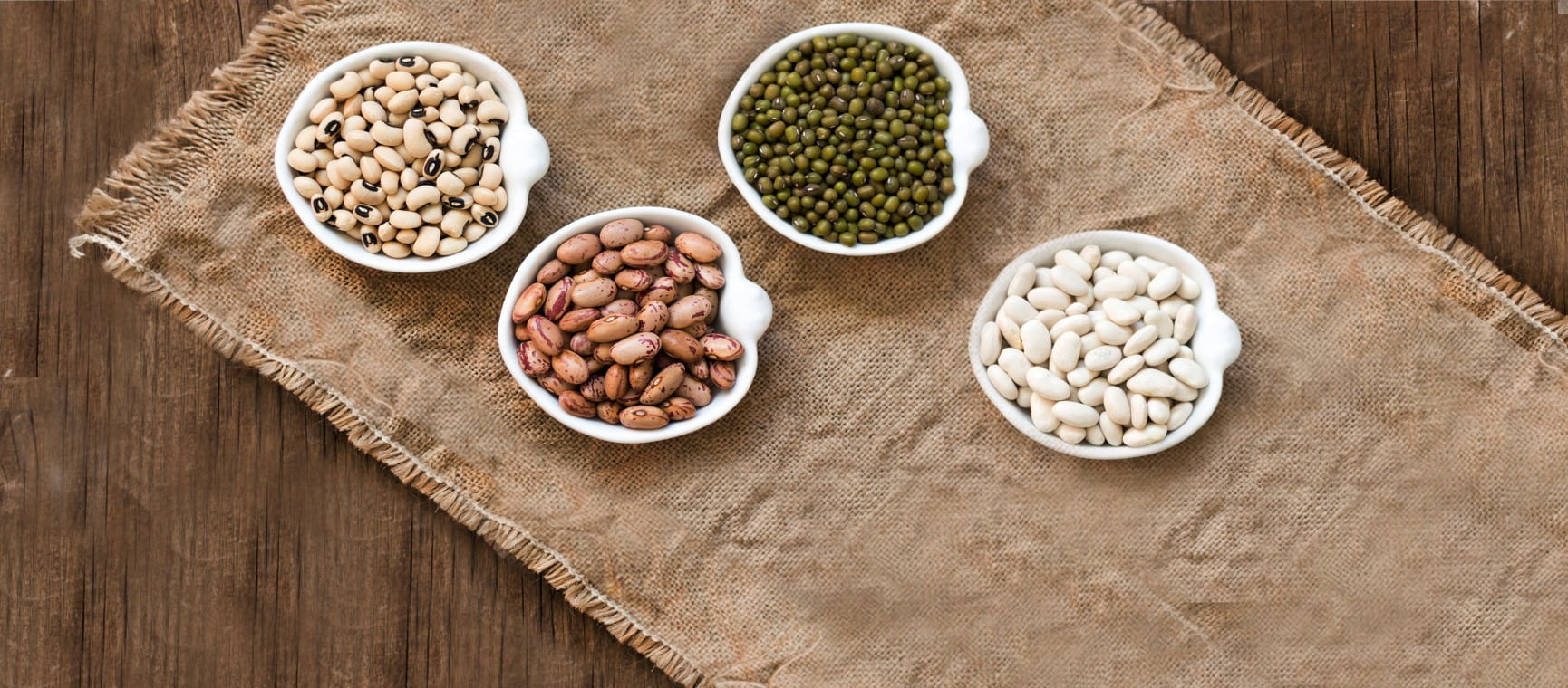 Assortment of legumes in bowls on wooden table | Getty/Karisssa