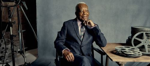 sir trevor mcdonald sat on chair by a table looking thoughtful