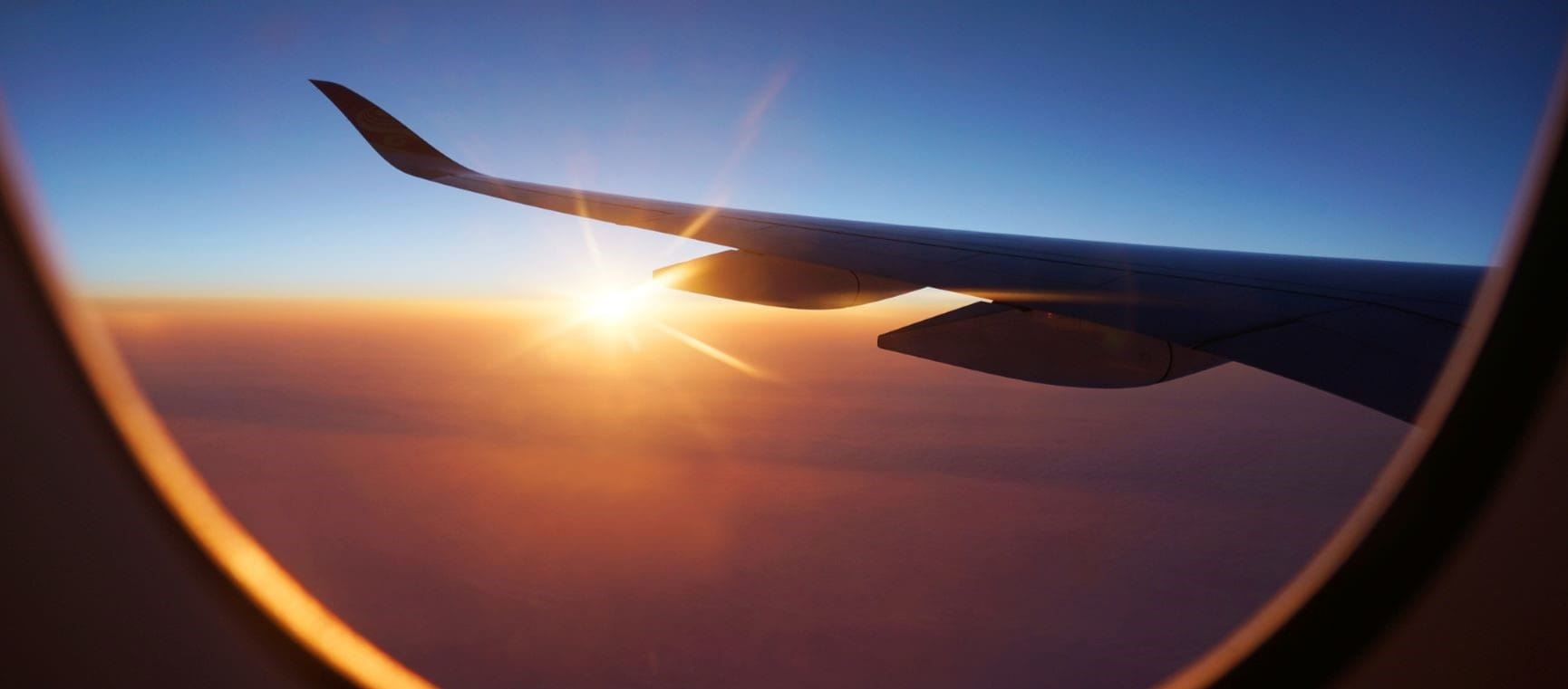plane wing out of the plane window at sunset